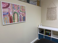 a room with a desk and a painting on the wall