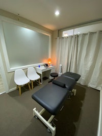 a room with a massage table and chairs