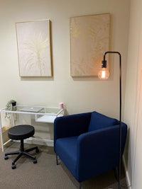 an office with a blue chair and a lamp